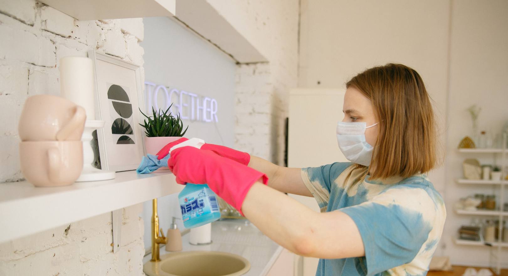 kobieta w maseczce sprząta mieszkanie w rękawiczkach