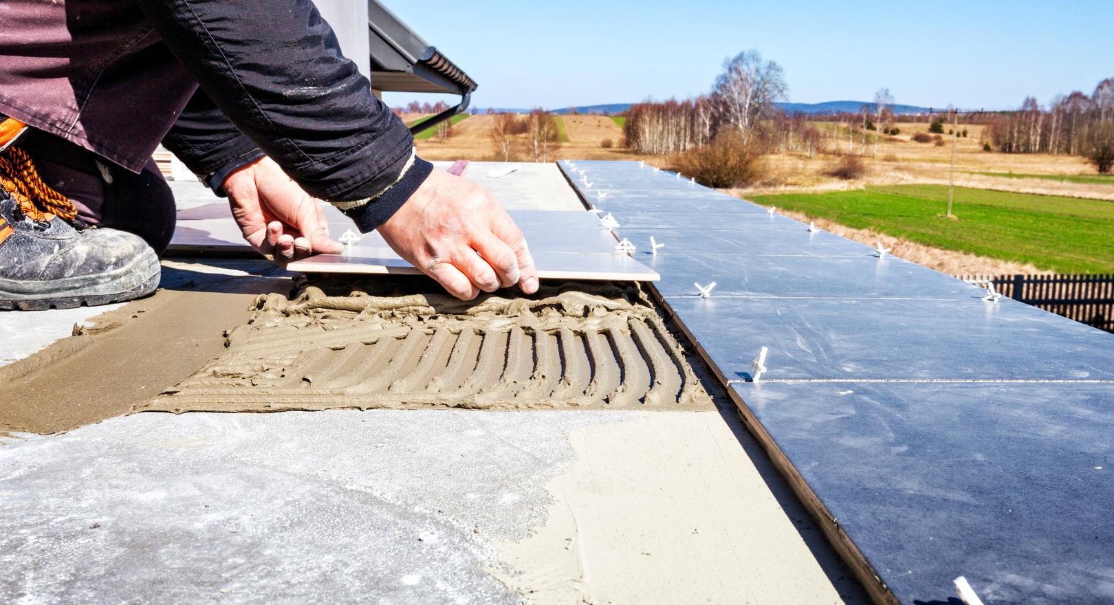 pracownik układa płytki na zewnątrz